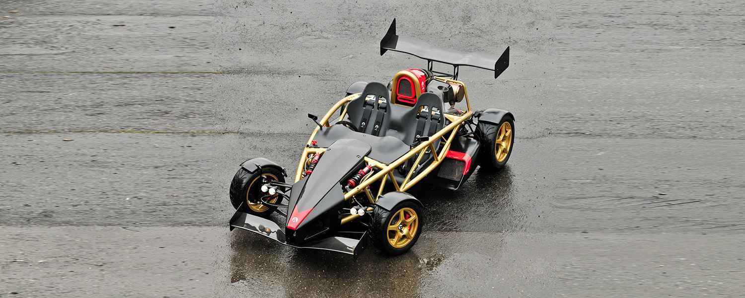 Ariel Atom with gold tubular chassis, visible suspension and a large rear wing