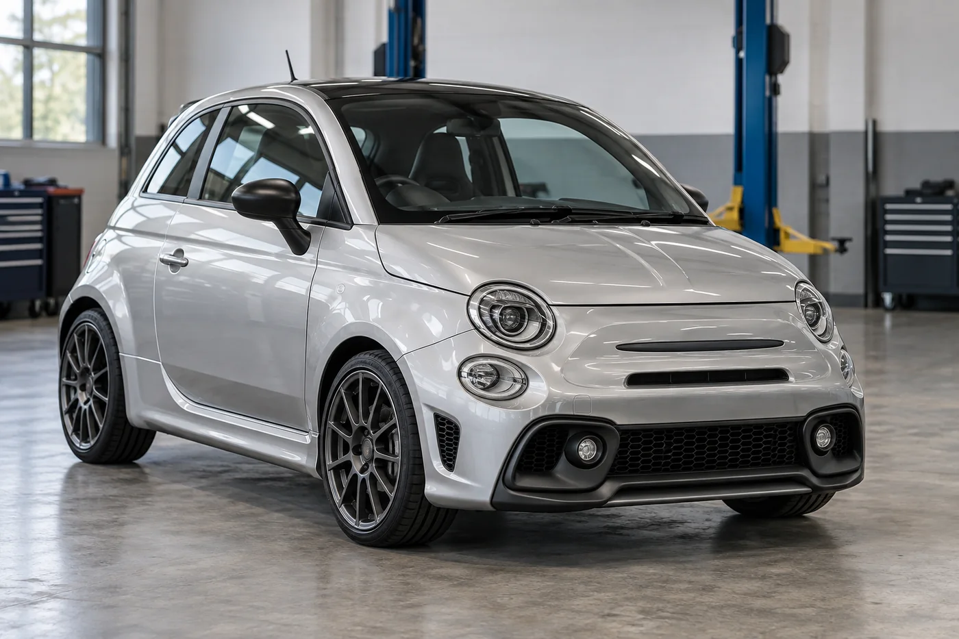 Representative silver Abarth-style hatchback in a workshop