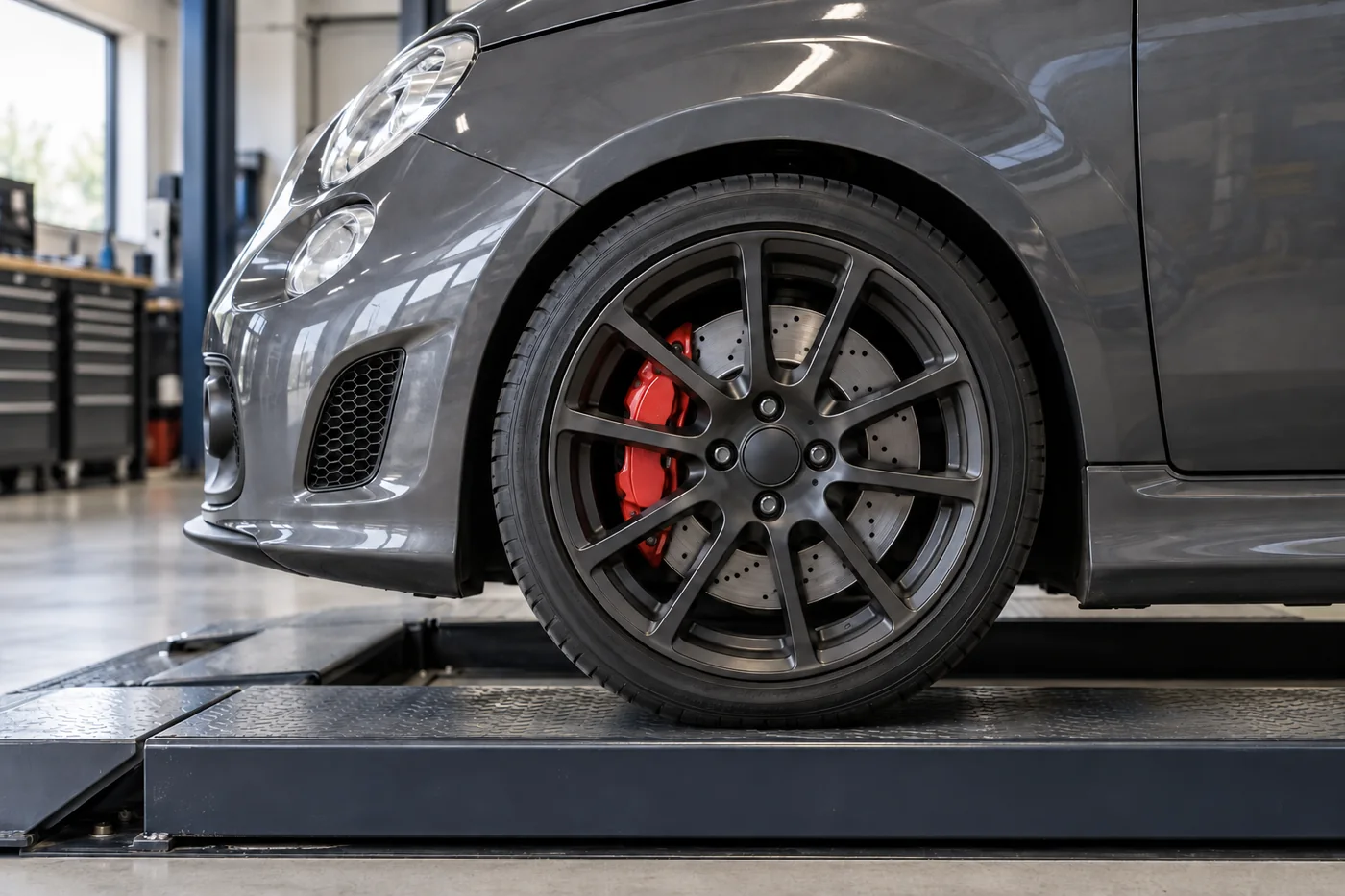 Representative compact performance-car wheel with brake disc and caliper visible