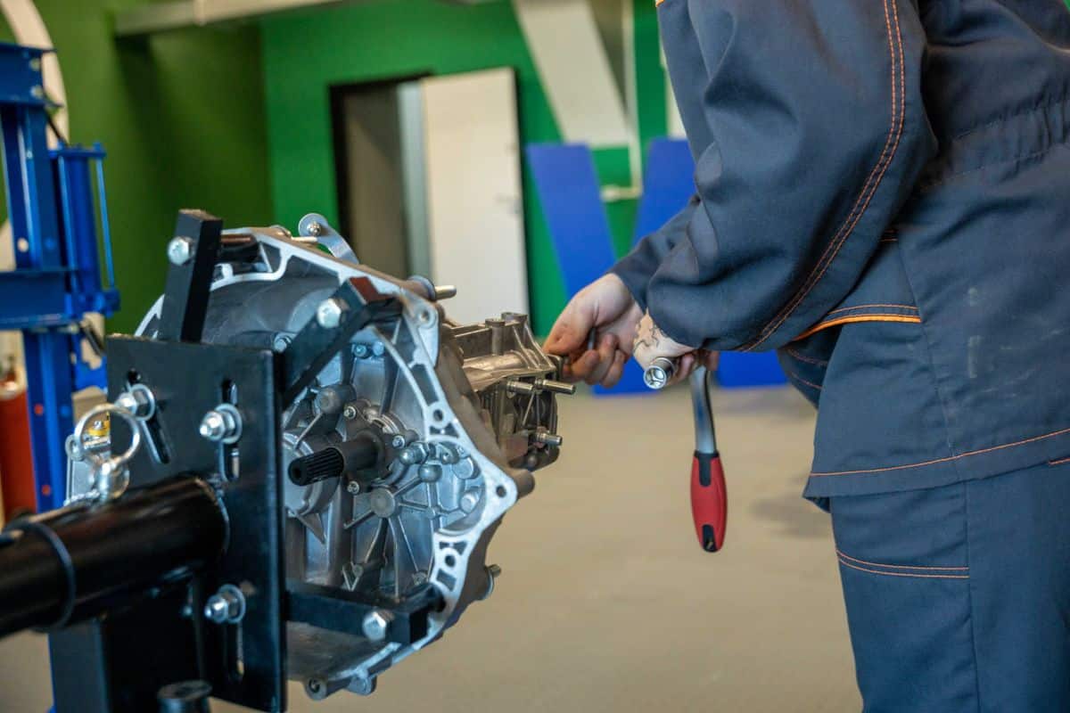 Mechanic working on a removed gearbox in a workshop