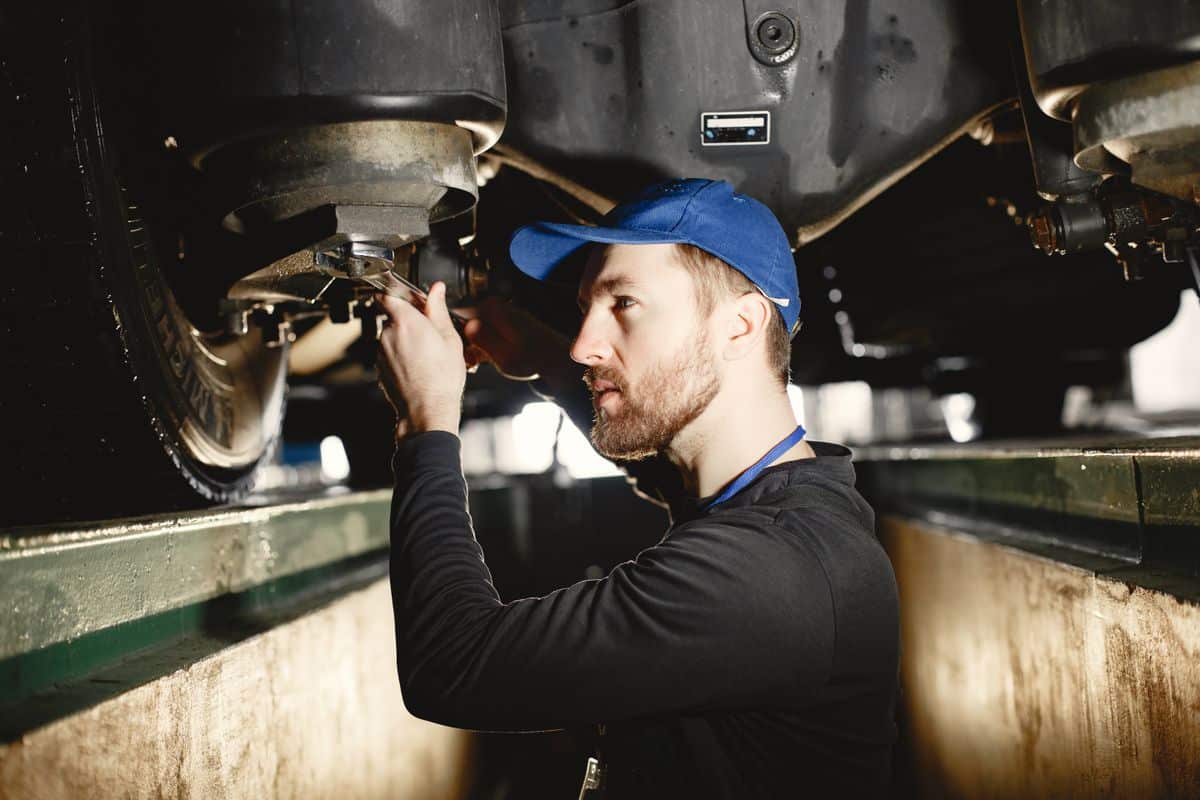 Mechanic accessing the underside of a vehicle during maintenance