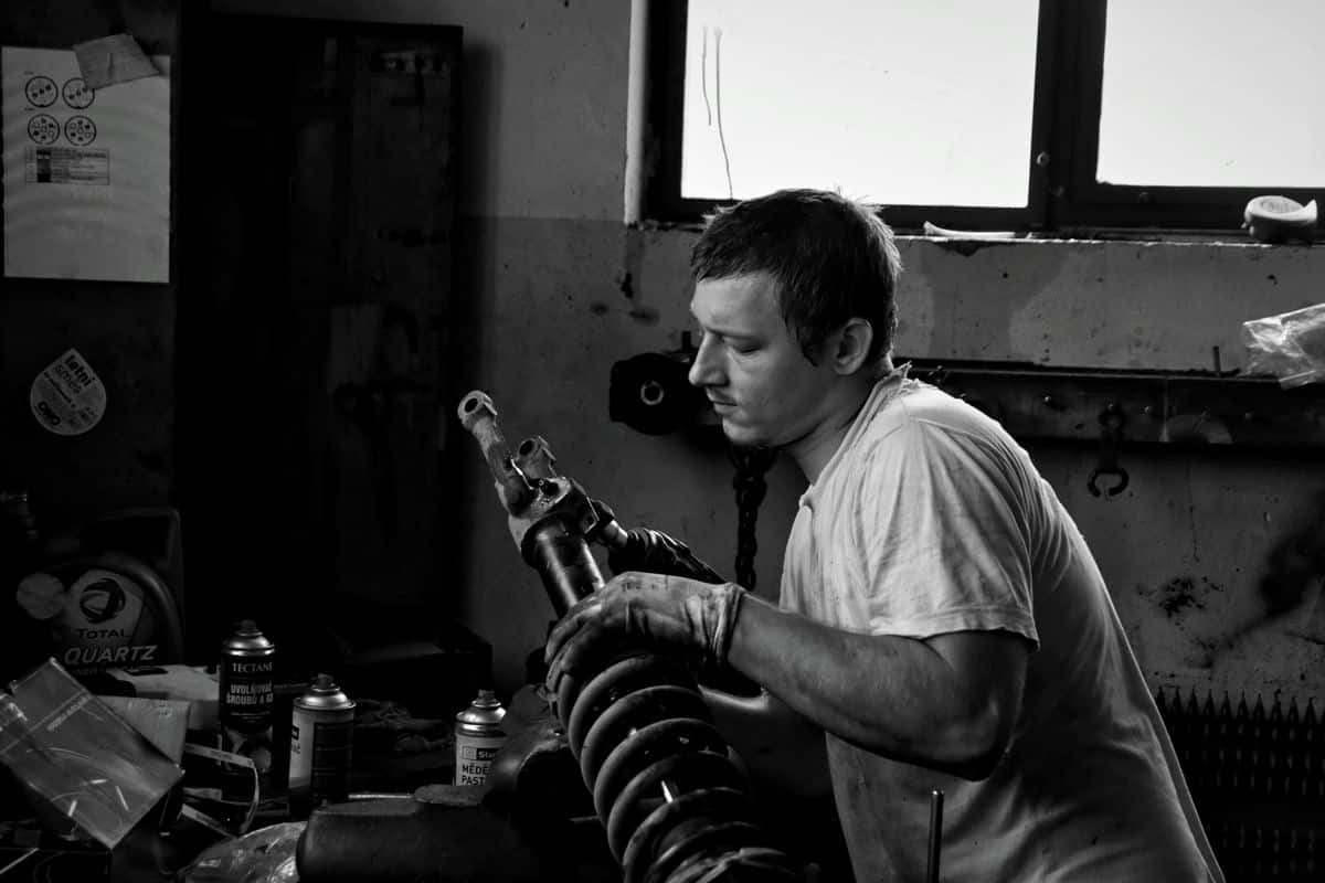 Mechanic examining a removed spring and strut assembly