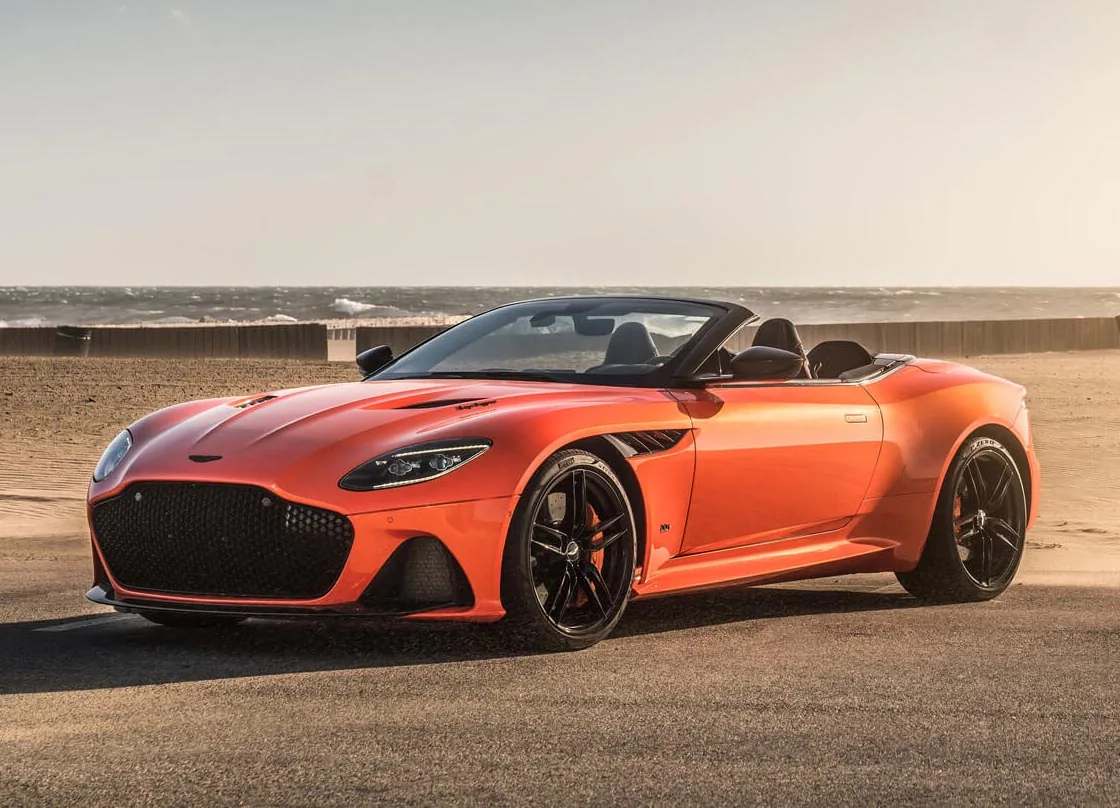 Orange Aston Martin DBS Superleggera Volante parked beside the coast