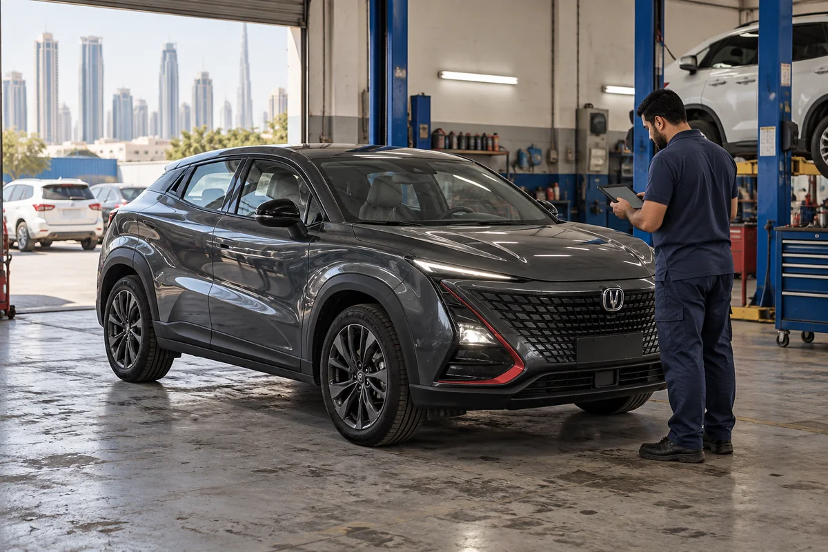 Technician reviewing a dark gray Changan UNI-T beside a workshop lift