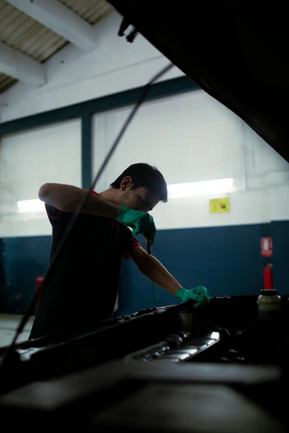 Technician checking engine oil with a dipstick