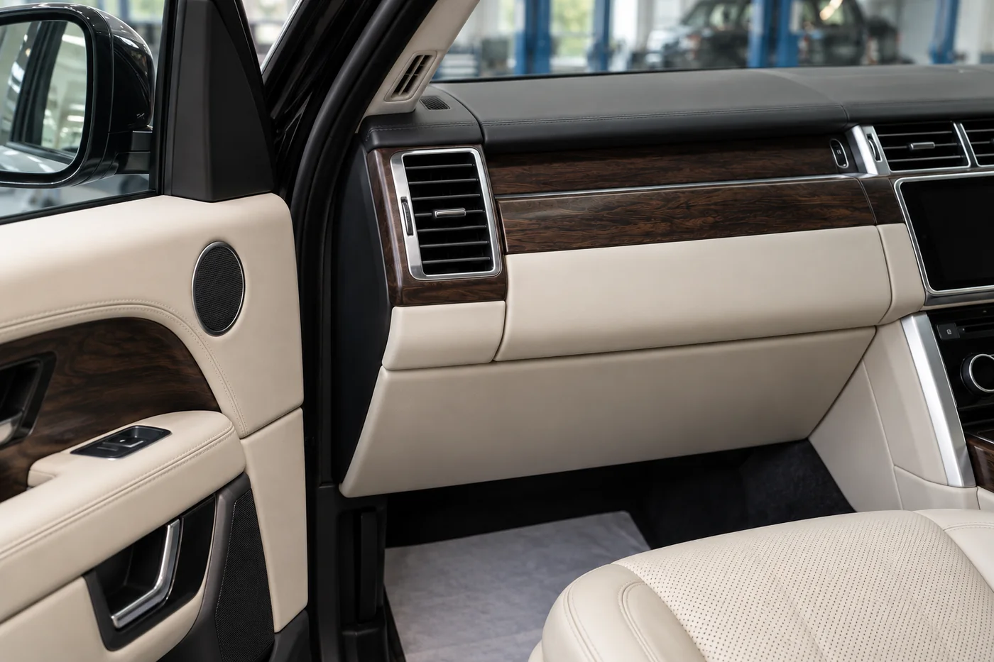 SUV passenger air vent, wood dashboard trim and cream leather interior