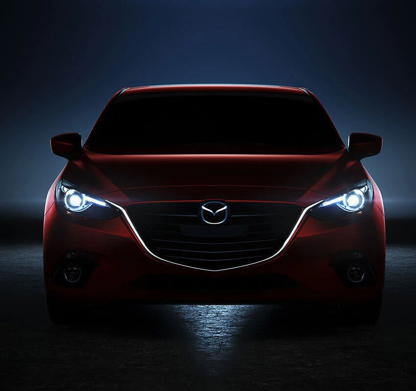 Red Mazda viewed from the front against a dark studio background