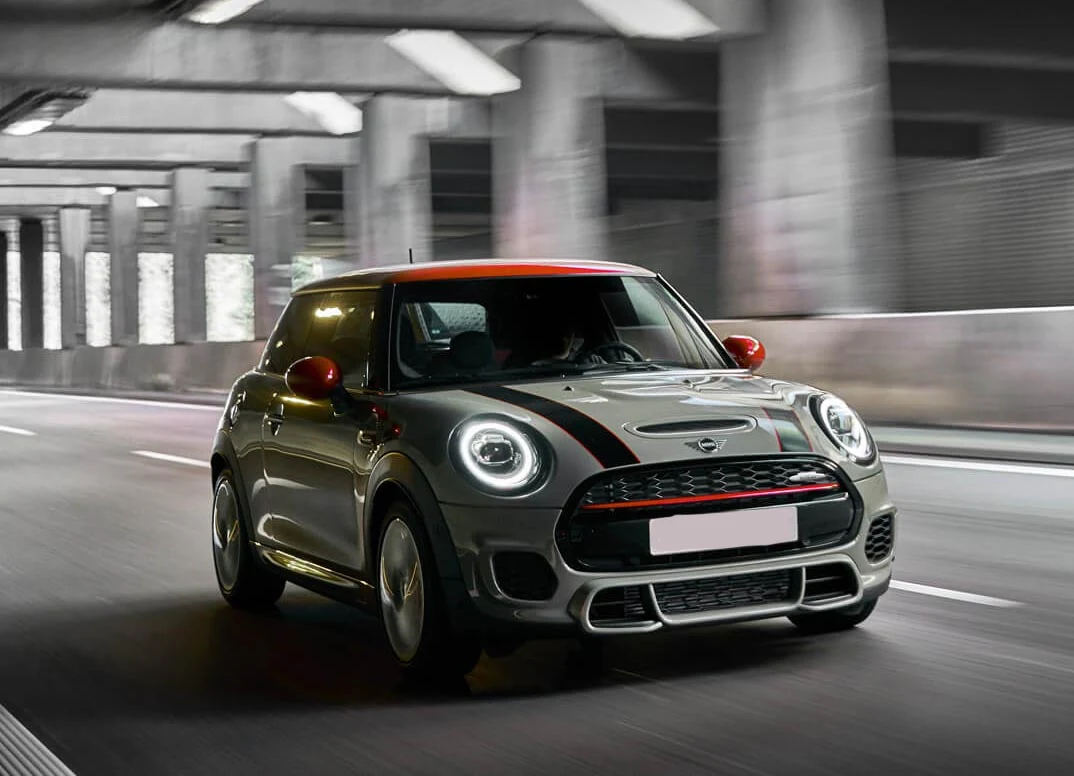 Grey MINI John Cooper Works with a red roof, viewed from the front and side
