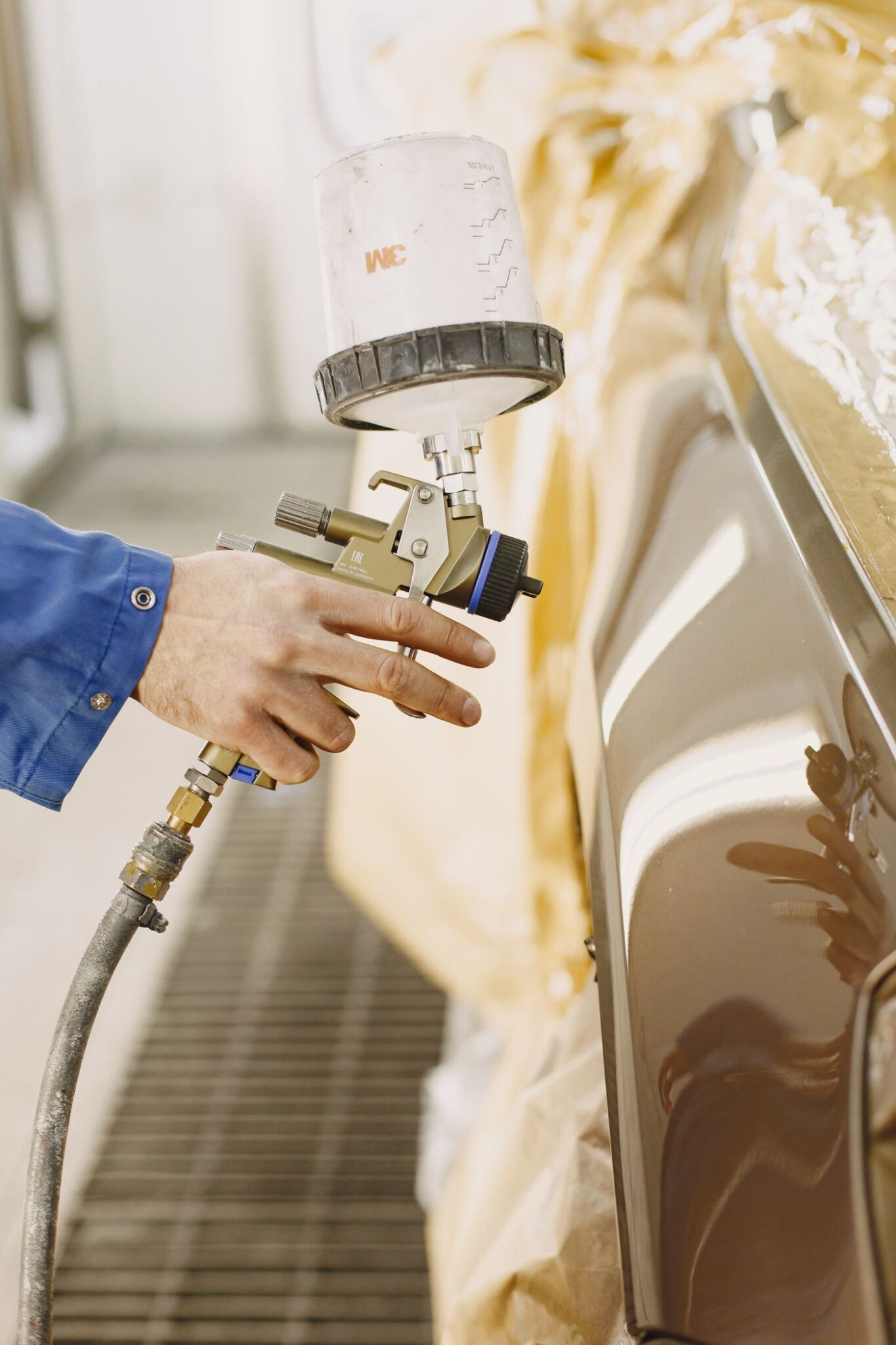 Technician applying paint finish to a vehicle body panel