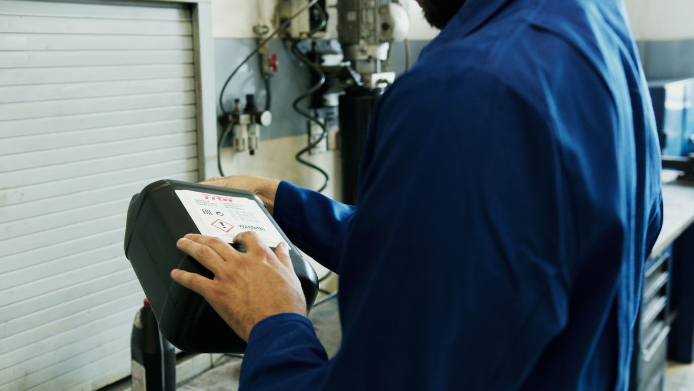 Technician using a diagnostic tablet beside a vehicle