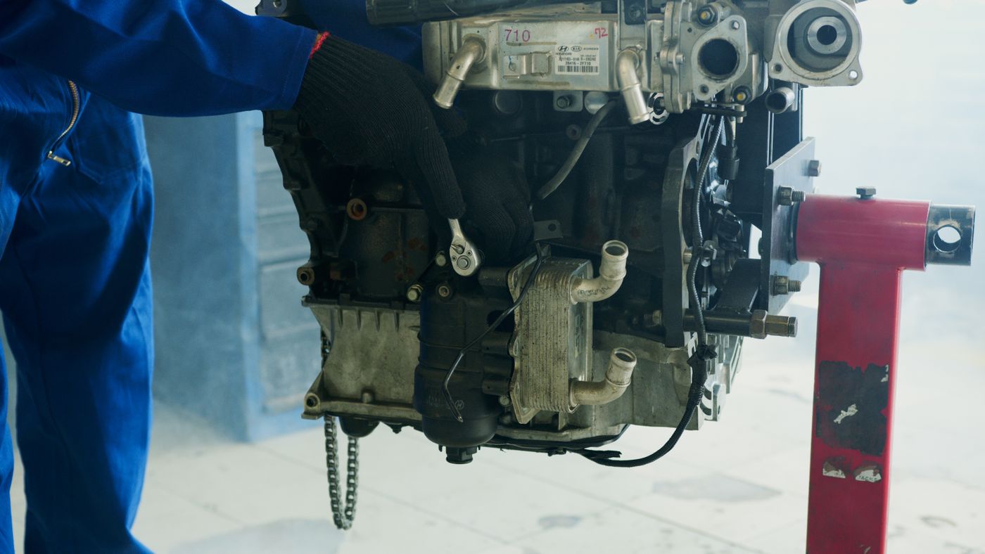 Technician working on an engine mounted on a workshop stand