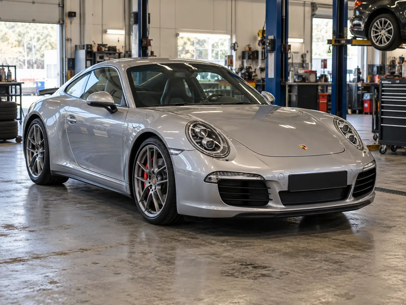 Silver Porsche 911 parked in an automotive workshop