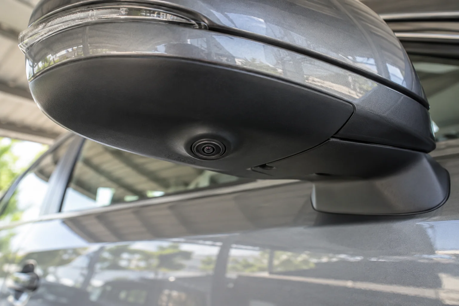 Small surround-view camera lens beneath an unfolded exterior side mirror
